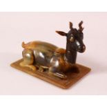 A 19TH CENTURY INDIAN CARVED HORN MODEL OF A RECUMBENT DEER, 12cm long.