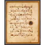 A FRAMED AND GLAZED KUFIC CALLIGRAPHIC MANUSCRIPT PAGE, double-sided, glazed on both sides,