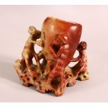 A GOOD CHINESE CARVED SOAPSTONE BRUSH WASH, the body carved with monkeys, 12cm high, 13cm wide.