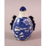 A CHINESE BLUE AND WHITE TWIN HANDLED PORCELAIN SNUFF BOTTLE, painted with dragons, 7cm.