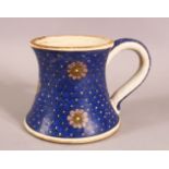 A TURKISH IZNIK POTTERY BLUE & WHITE CUP - decorated with floral rounds, with large handle, 15cm