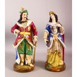 A PAIR OF TURKISH PORCELAIN SULTAN & SULTANA - both in traditional gowns holding objects, 38cm high