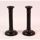 A PAIR OF INDIAN TURNED EBONY CANDLESTICKS, 20cm high.