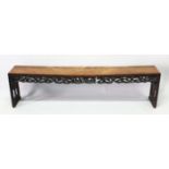 A CHINESE HARDWOOD BENCH SEAT with pierced and carved frieze and end supports, 187cm long, 27cm