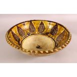 A NISHAPUR YELLOW GLAZED POTTERY BOWL, the centre with a stylised bird, 30cm diameter.