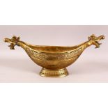 A LARGE INDO PERSIAN BRASS KASHKUL BOWL with dragon head terminals, 45cm long.