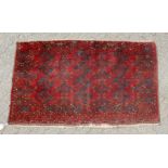 A SMALL PERSIAN BASHIR RUG, red ground with three small rows of four motifs. 5ft x 3ft.