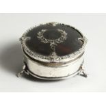 A GEORGE V SILVER AND TORTOISESHELL CIRCULAR PIN BOX, on three legs. 2.5ins diameter, Birmingham