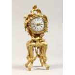 A GROUP SMALL 19TH CENTURY FRENCH GILT METAL CLOCK on a stand with putti and garlands. 8.5ins high.