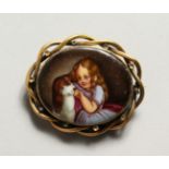 A VICTORIAN OVAL PORCELAIN BROOCH of a young girl with a dog.