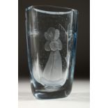 A HEAVY BLUE TINTED SWEDISH VASE etched with a lady standing beside a tree. Signed 10.5ins high.