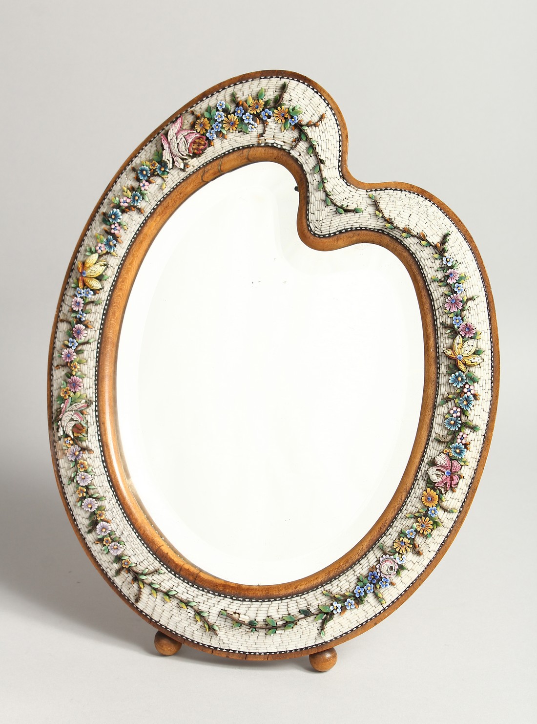 A GOOD MOSIAC FRAMED SHAPED EASEL MIRROR with a band of flowers 13.5ins high.