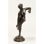 AFTER THE ANTIQUE. A GOOD BRONZE OF A NUDE holding her left leg, on a circular base. 10ins high.