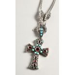 A SILVER TURQUOISE AND GARNET CROSS on a silver chain.