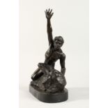 A BRONZE NUDE MAN on a rock with arms raised. 14ins high