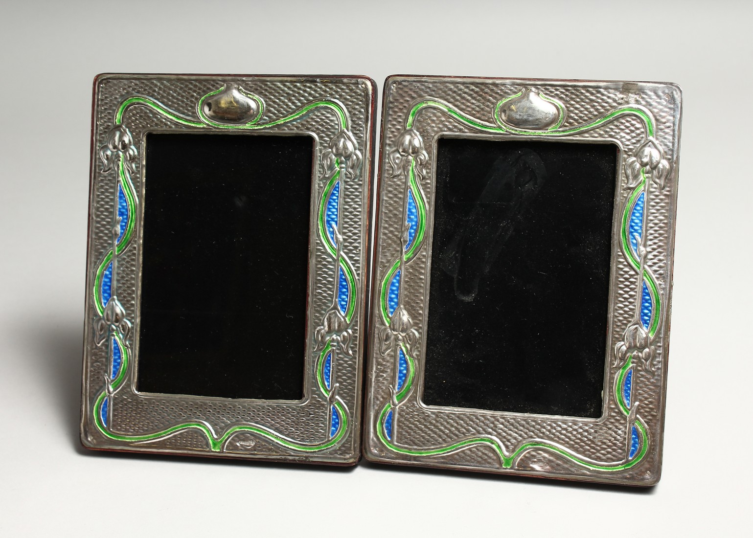 A PAIR OF SILVER AND ENAMEL PHOTOGRAPH FRAMES 7.5ins x 5.5ins