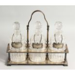 A VERY GOOD VICTORIAN, GILDED PLATE THREE BOTTLE DECANTER STAND, with oval bottles and stoppers,