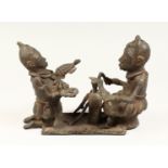 AN UNUSUAL"BENIN" BRONZE GROUP DEPICTING TWO FIGURES FACING ONE ANOTHER, one a blacksmith, the other
