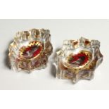 A PAIR OF CUT GLASS SALTS, with cranberry tinted and gilt decorated portraits to the bases. 3ins
