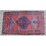 A GOOD SMALL PERSIAN RUG, deep red ground with a central large medallion, flanked by stylised vases.