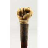 A GOOD VICTORIAN WALKING STICK WITH CARVED IVORY HANDLE OF A CLENCHED FIST CLUTCHING A SNAKE with