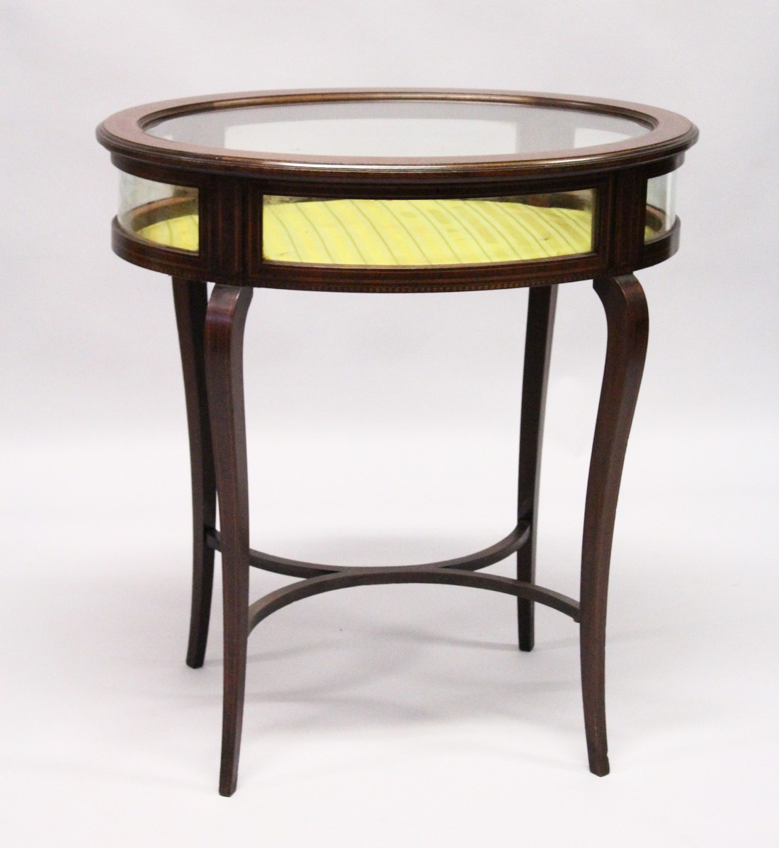 A GOOD EDWARDIAN MAHOGANY OVAL BIJOUTERIE TABLE with rising glass top , glass sides on curving