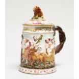 A CAPODIMONTE PORCELAIN TANKARD AND COVER, classical scene in relief. Blue N mark. 7ins high.