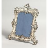 A VICTORIAN PLATE PHOTOGRAPH FRAME with scrolls 9ins x 7ins.