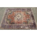 A LARGE PERSIAN CARPET, rust ground central panel, with all over stylised flora decoration ( some