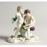 A 19TH CENTURY MEISSEN PORCELAIN GROUP OF TWO PUTTI, one as a scribe (A F one arm missing) 4.5ins