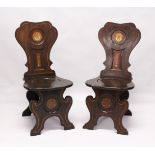 A GOOD PAIR OF REGENCY MAHOGANY HALL CHAIRS with shaped backs with painted crest, solid seats