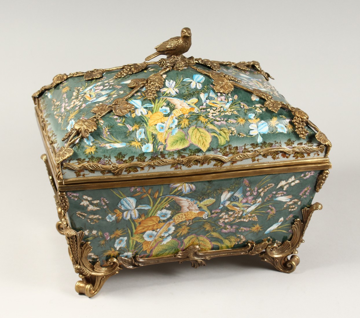 A LARGE CONTINENTAL STYLE PORCELAIN AND BRONZE MOUNTED CASKET, decorated with exotic flowers and