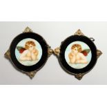 A PAIR OF CIRCULAR PLAQUES OF CHERUBS 6ins diameter.