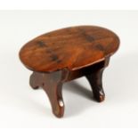 AN EARLY TREEN OVAL STOOL 9ins long, 5.5ins wide, 5ins high Stamped G.F.