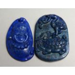 TWO SMALL CARVED LAPIS PENDANTS.