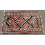 A MID 20TH CENTURY MALAYER RUG, bright red ground with three central lozenges. 6ft 5ins x 3ft