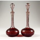 A PAIR OF RUBY OVERLAID AND GILT DECORATED CUT GLASS PERFUME BOTTLES 8.5ins high