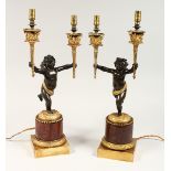 AS VERY GOOD PAIR OF REGENCY BRONZE AND ORMOLU TWO BRANCHED CHERUB CANDLESTICK each holding