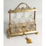 A VERY GOOD VICTORIAN, GILDED PLATE, THREE BOTTLE TANTALUS with acanthus scrolled handles,