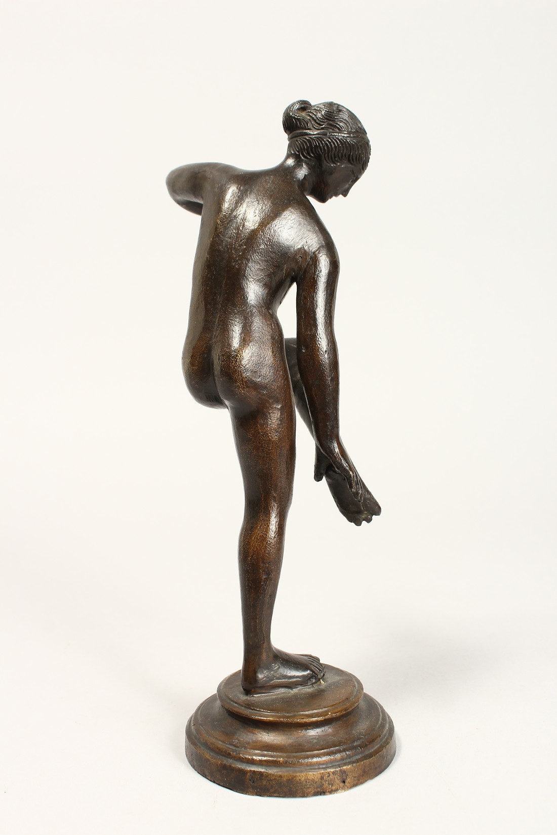 AFTER THE ANTIQUE. A GOOD BRONZE OF A NUDE holding her left leg, on a circular base. 10ins high. - Image 3 of 4