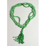 A VERY GOOD STRING OF JADE BEADS with a gold and diamond clasp.
