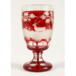 A GOOD BOHEMIAN RUBY GLASS GOBLET etched with deer in a landscape.