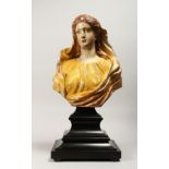 A 18TH CENTURY WOOD AND POLYCHROME DECORATED BUST OF A YOUNG LADY, on ebonised stepped base Bust