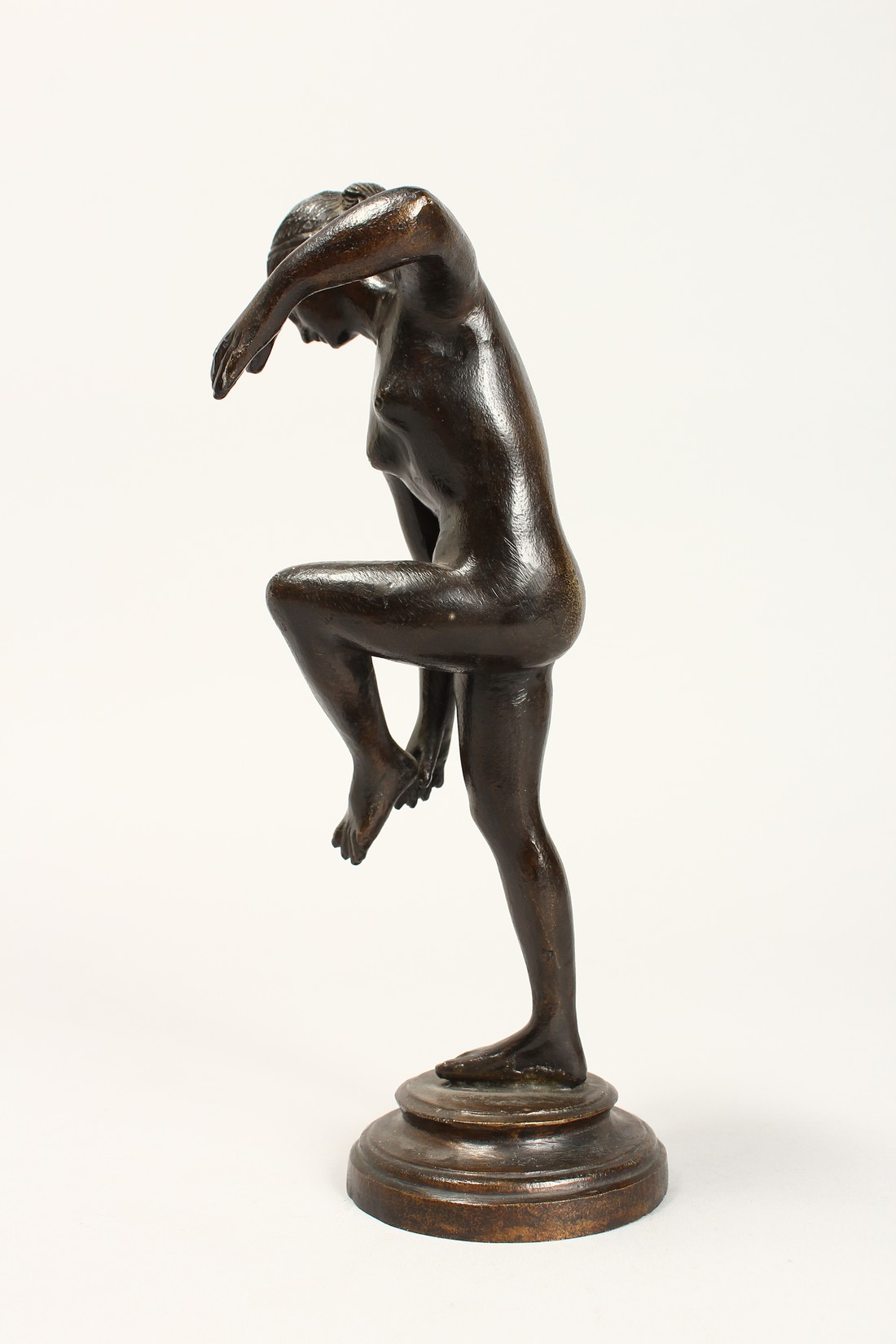 AFTER THE ANTIQUE. A GOOD BRONZE OF A NUDE holding her left leg, on a circular base. 10ins high. - Image 2 of 4