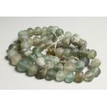 A STRING OF EARLY GREEN GLASS BEADS 40ins long