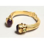 A GOOD TORQUE STYLE SPRING GILDED SILVER BANGLE, set with a pair of cabochon amethysts, two pear