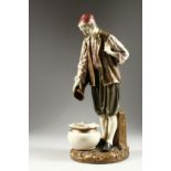 A ROYAL WORCESTER PORCELAIN FIGURE OF A TURK by Hadley, standing, pouring from a jug, into a bowl.