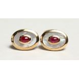 A PAIR OF 9CT. YELLOW GOLD, RUBY AND MOTHER OF PEARL OVAL CUFFLINKS