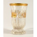 A GOOD BOHEMIAN GILT DECORATED GOBLET with handle, with a scene of buildings 4.75ins high.
