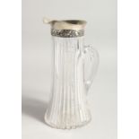 A SILVER MOUNTED GLASS JUG. 9.5ins high